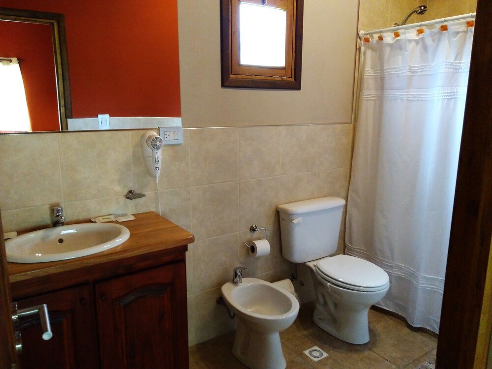 Bathroom with a sink, a bidet, a toilet and a shower curtain