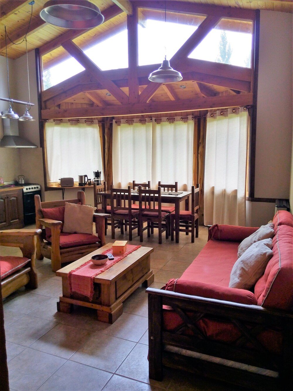 Cozy living room with a wooden ceiling and a dining area