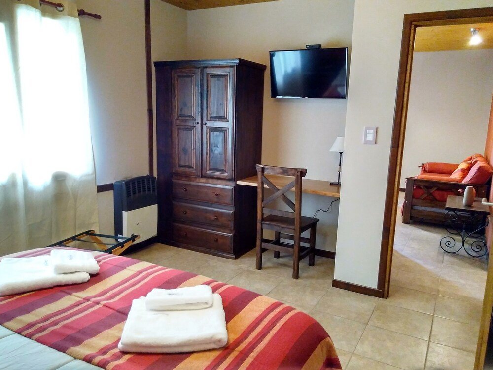 Room with a bed, a desk, a television and a wardrobe