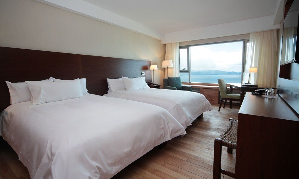 Habitación con dos camas, escritorio y vista