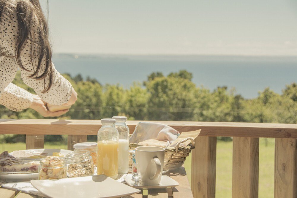 Mesa de desayuno con comida y bebidas frente a una vista panorámica