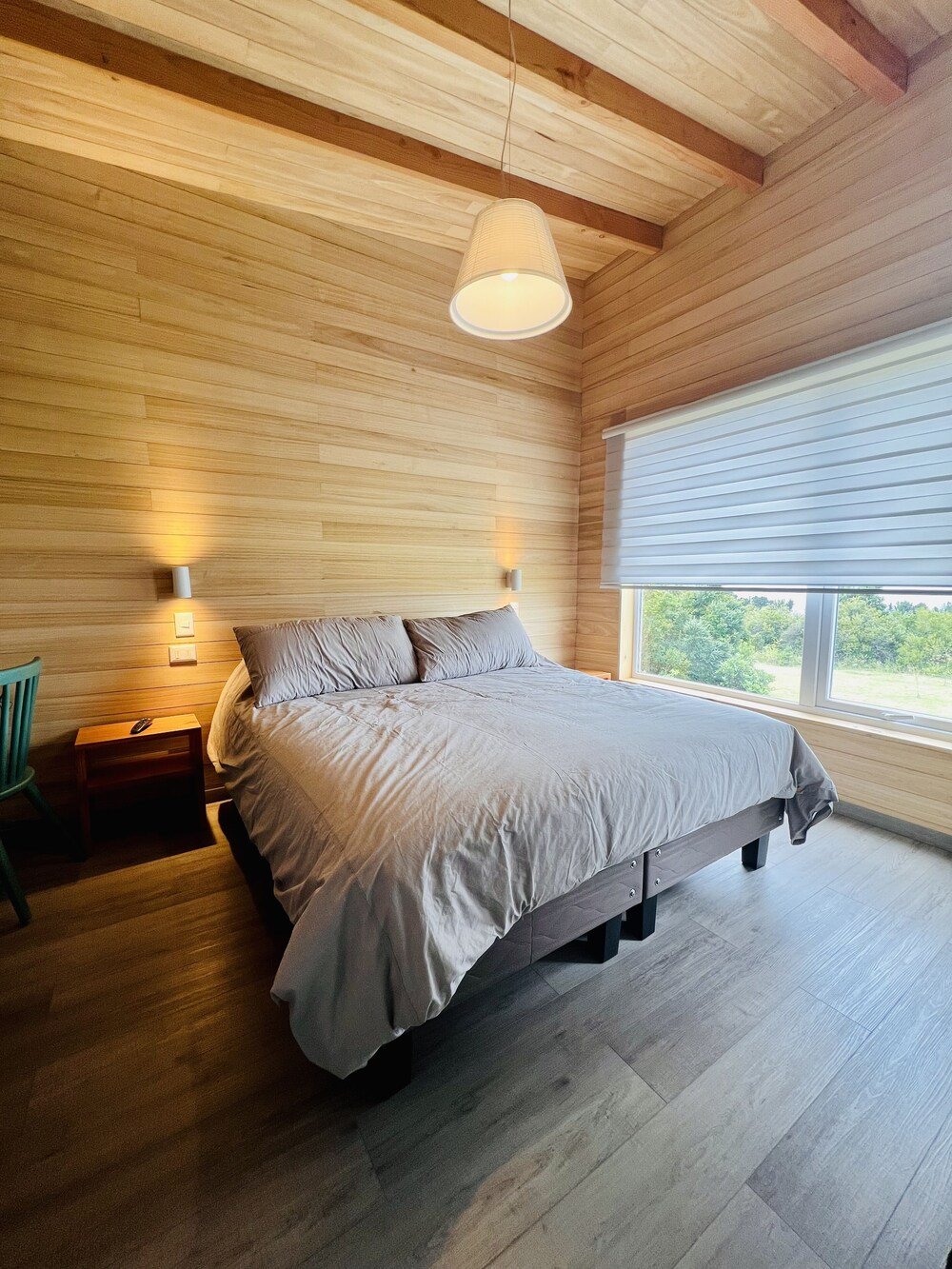 Bedroom with wooden ceiling and view of greenery from window
