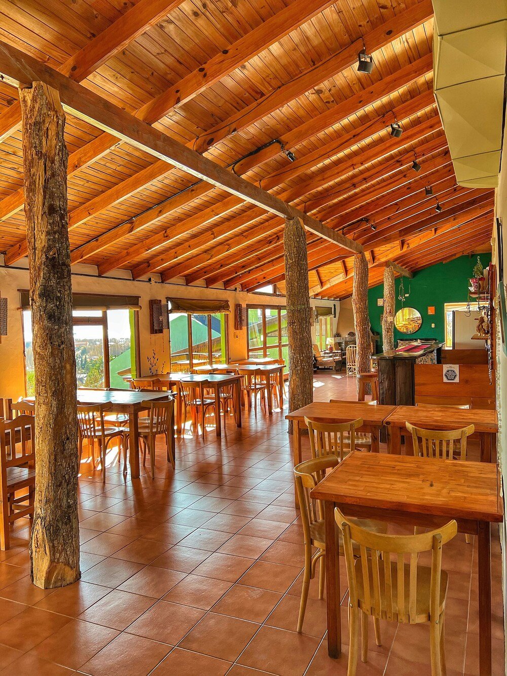 Comedor con mesas de madera y techo alto de madera