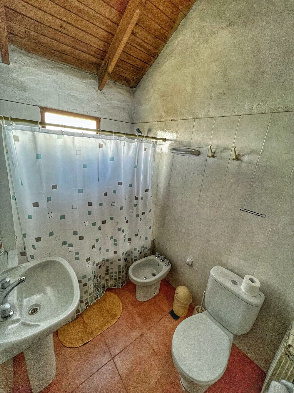 Baño pequeño con cortina de ducha, lavatorio, inodoro y bidet