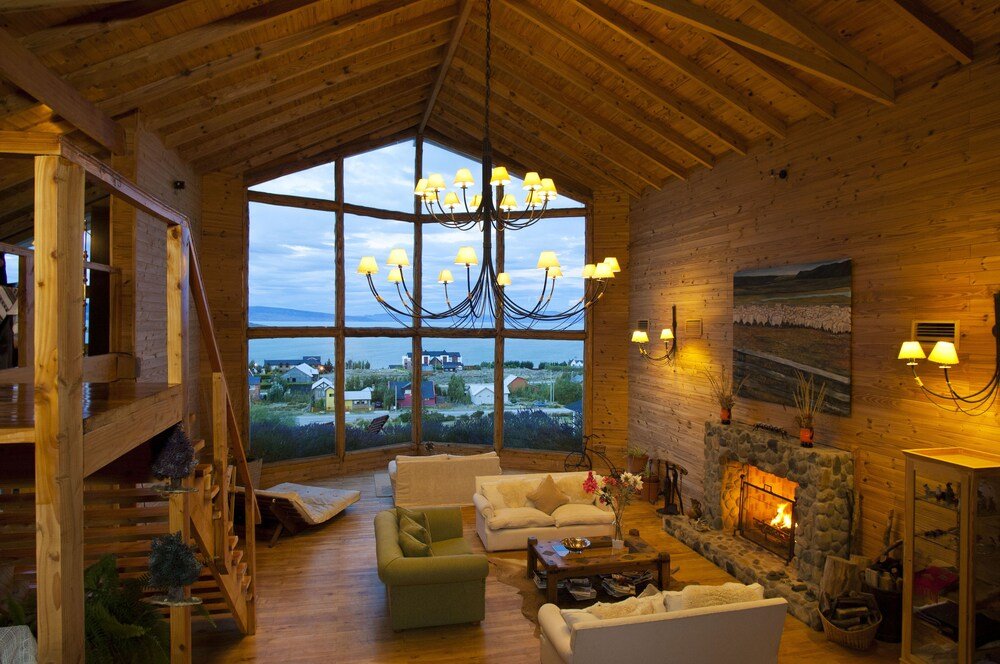 Living amplio con un gran ventanal y hogar de piedra