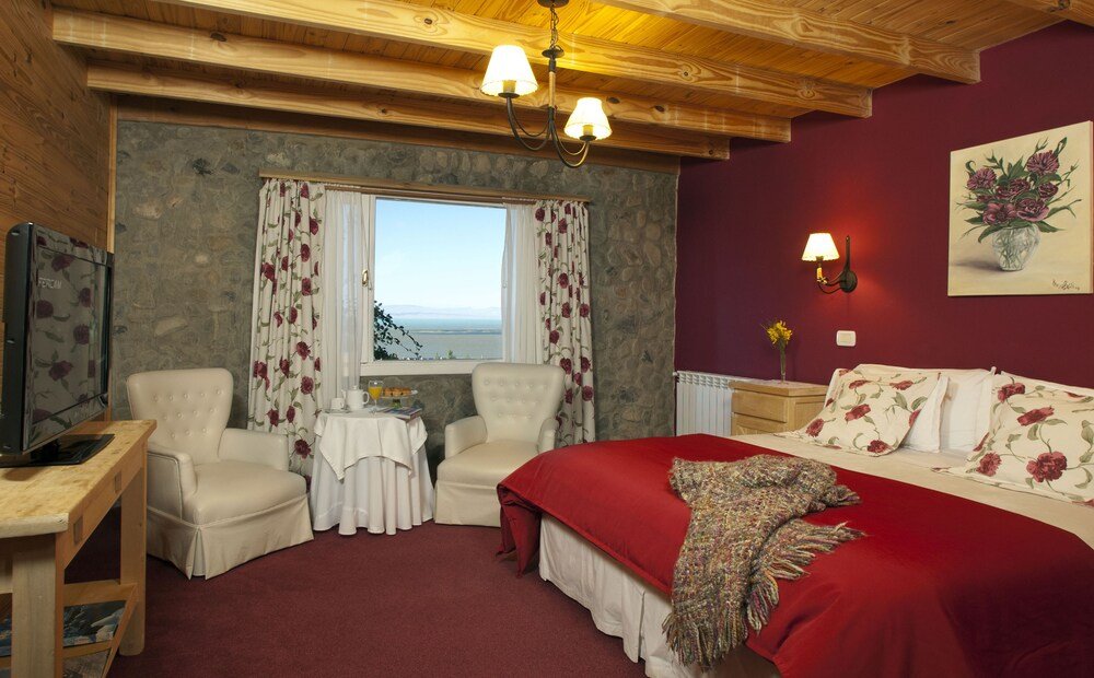 Habitación acogedora con cama, dos sillas y una ventana