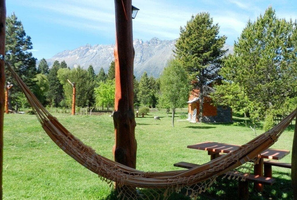 Hammock on a grassy area with picnic tables and a mountain view