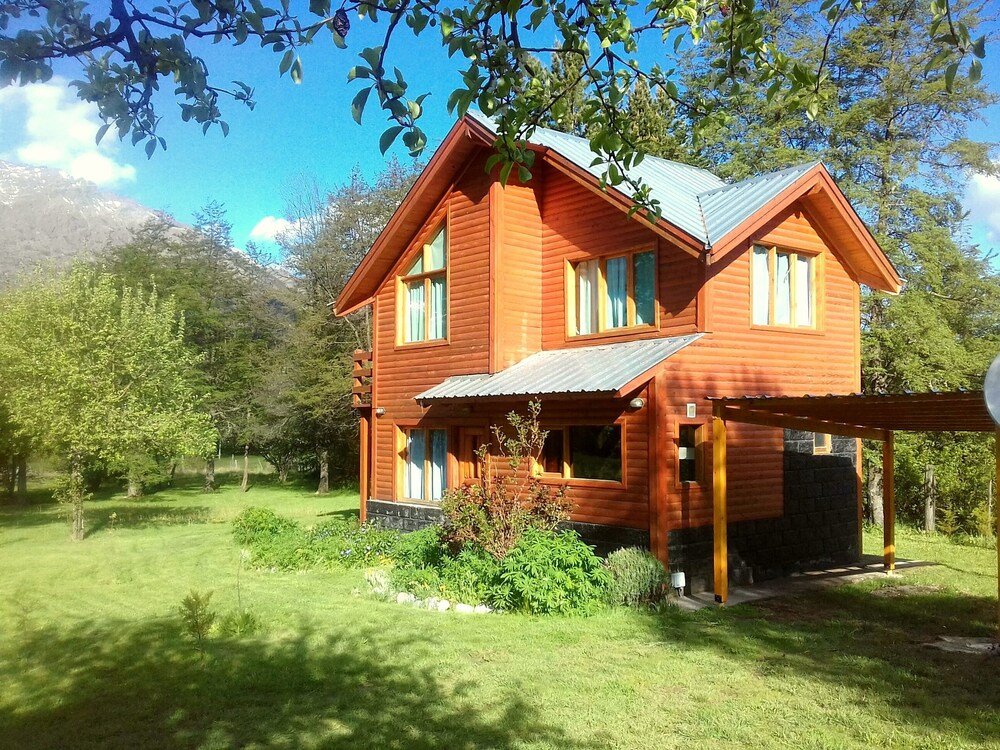 Two-story wooden house with a porch and a well-kept garden