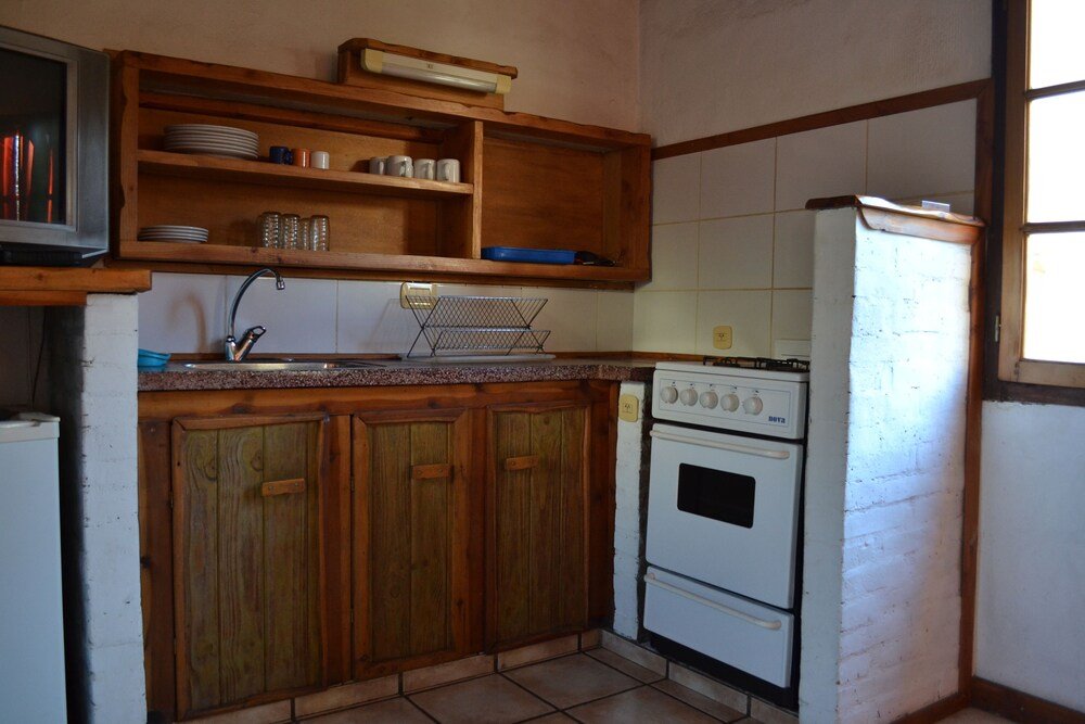 Kitchen with wooden cabinets, a stove and a refrigerator