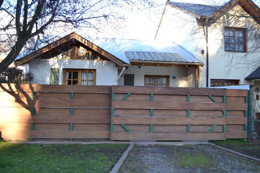 Wooden fence in front of a house with a metal roof