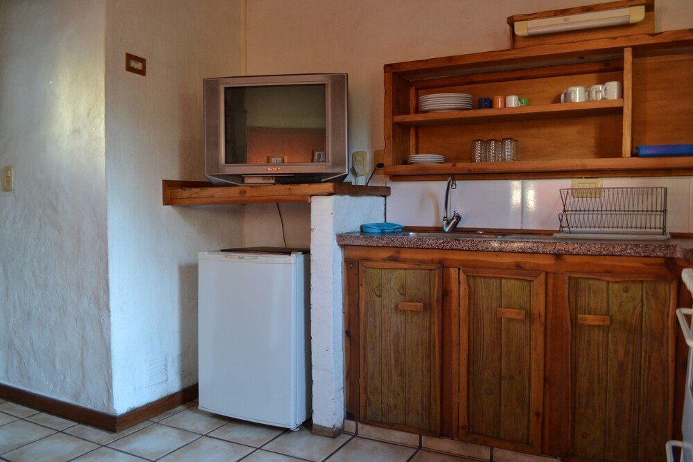 Compact kitchen with a built-in refrigerator and a wooden countertop
