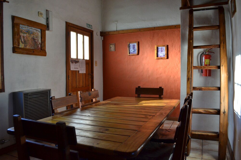 Dining area with a long wooden table, benches and a wooden ladder