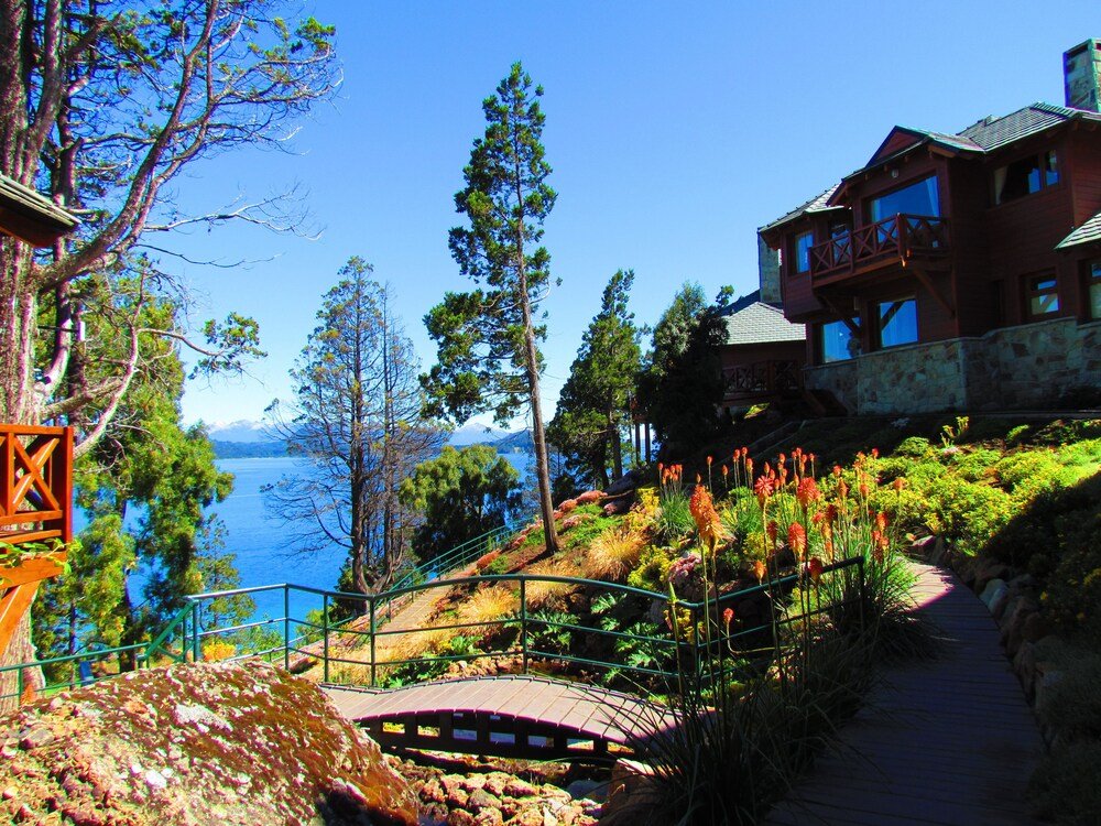 Wooden bridge leading to a stone building at Charming Luxury Lodge