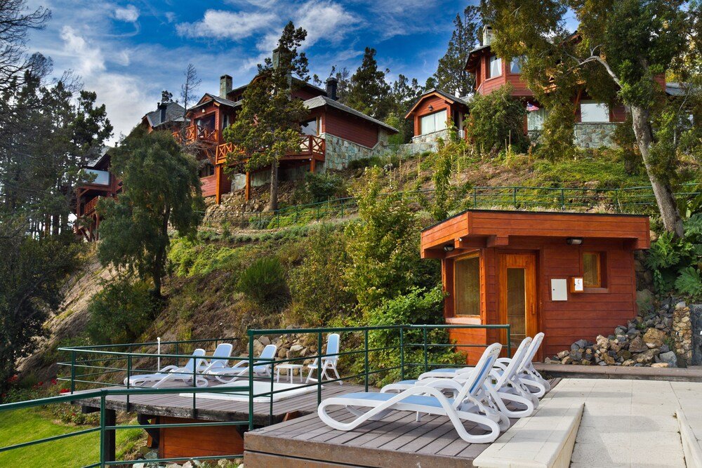 Hillside resort with several wooden buildings at Charming Luxury Lodge