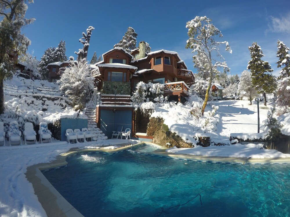 Snow-covered landscape with a cabin at Charming Luxury Lodge