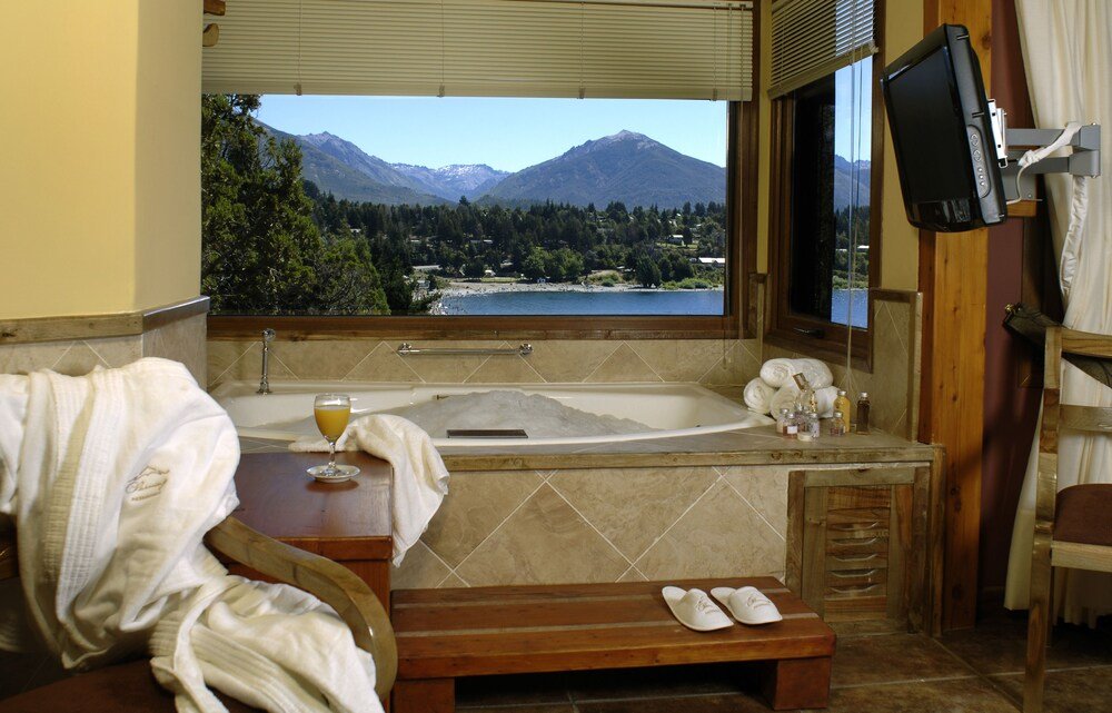Bathroom with a bathtub and a window at Charming Luxury Lodge