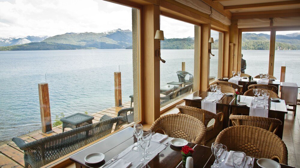 Restaurant with tables set for dinner at Correntoso Lake & River Hotel