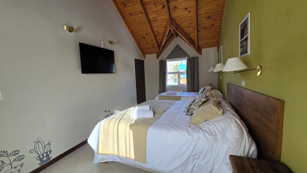 Habitación con techo de madera y TV de pantalla plana