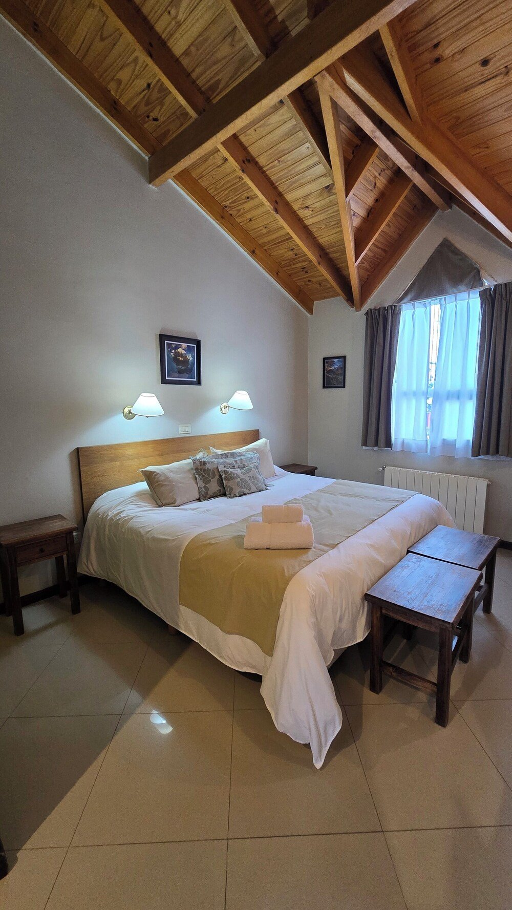 Dormitorio con techo de madera y cama grande