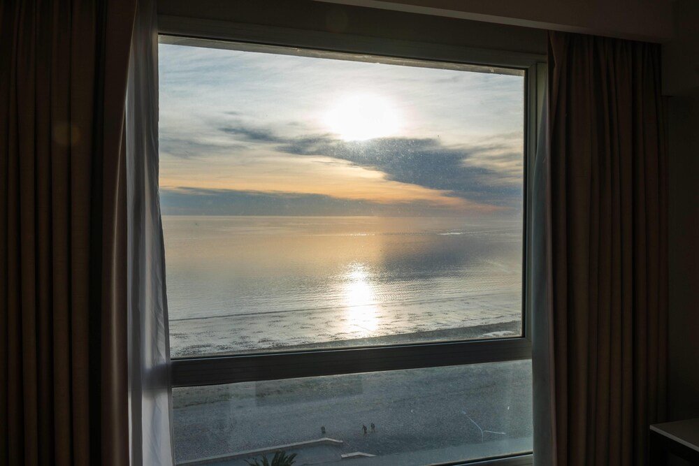 Habitación del hotel con un gran ventanal hacia la ciudad