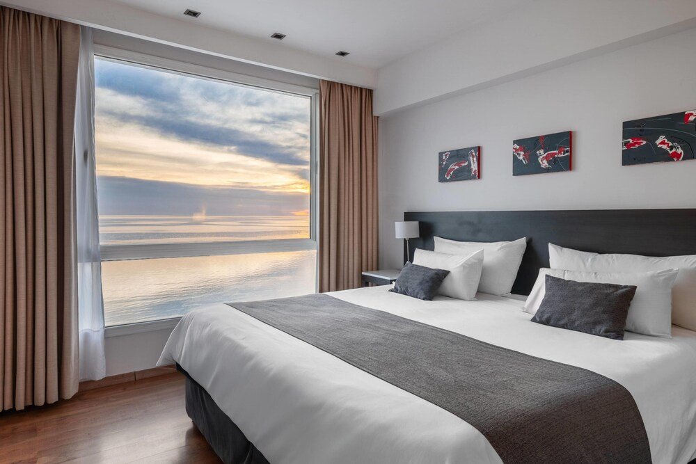 Habitación del hotel con cama grande y ropa de cama neutra