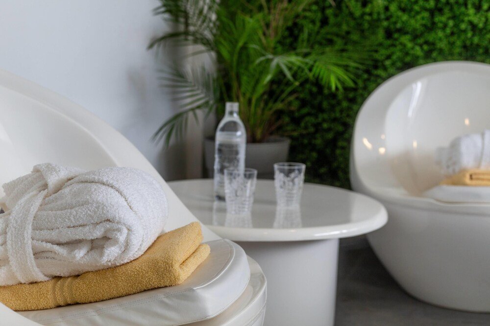 Zona de spa con una bañera blanca y toallas dobladas