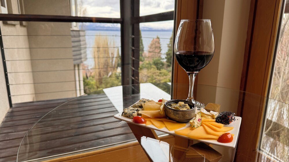 Table with a glass of red wine at Design Suites Bariloche