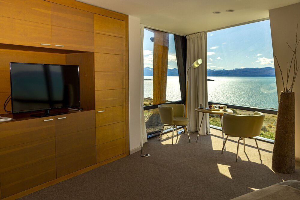 Habitación moderna con TV, comedor y vista al lago