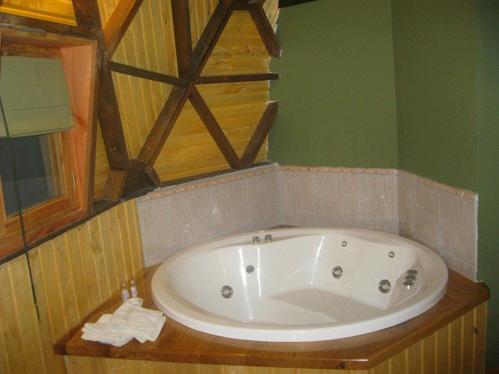 Bathroom with a wooden vanity, a bathtub and a mirror