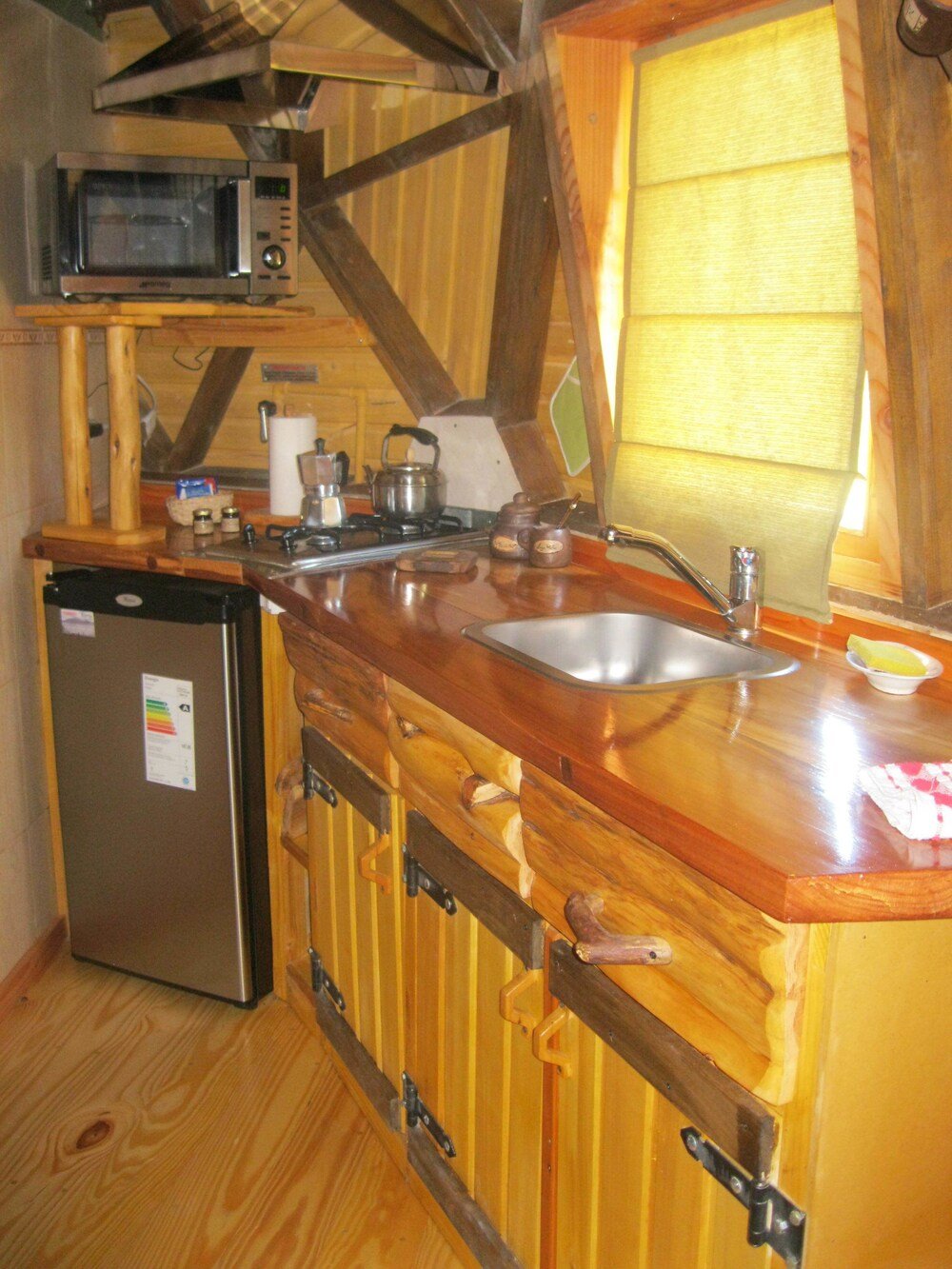 Compact kitchen with a built-in microwave and a steel sink
