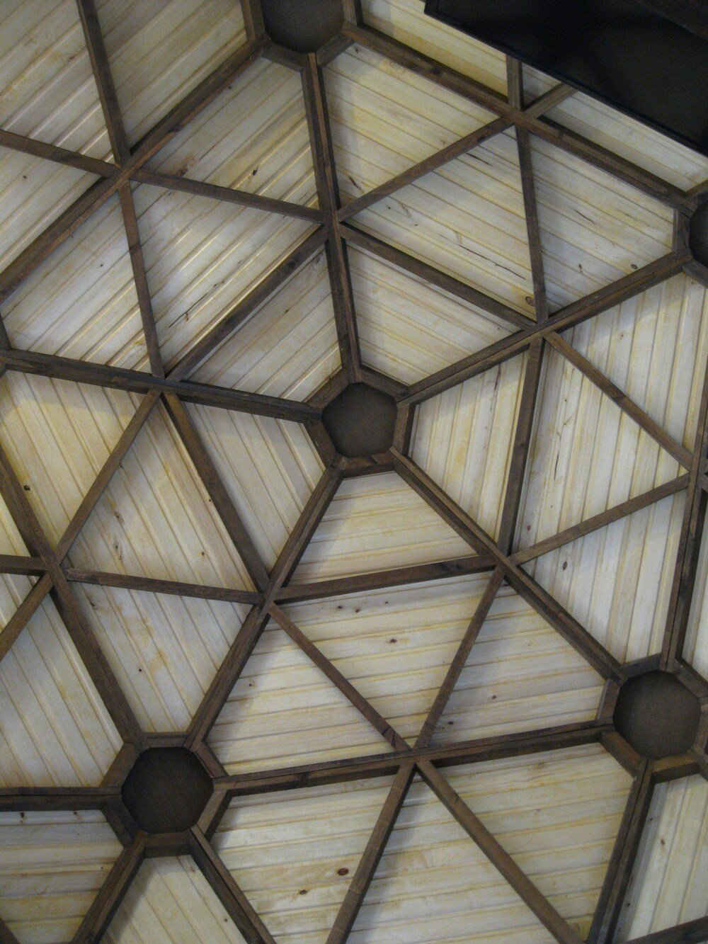 Geometric ceiling with intersecting wooden beams and panels