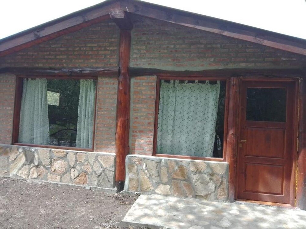 Edificio con frente de ladrillo, base de piedra y puerta de madera
