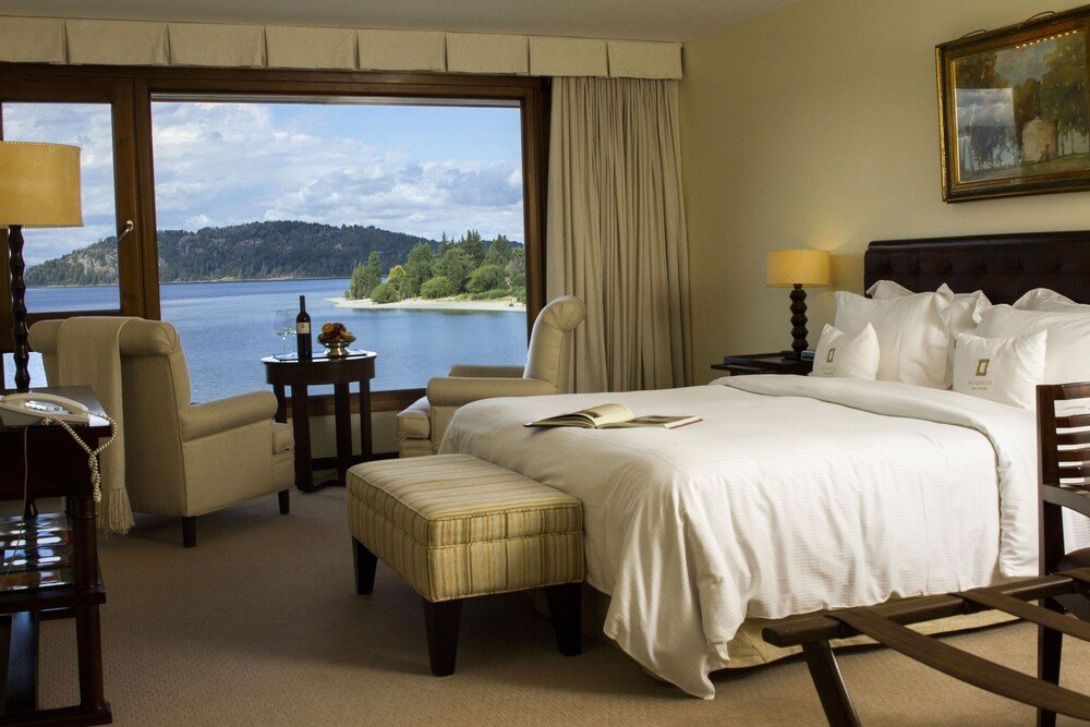 Habitación con un gran ventanal con vista al lago y al bosque