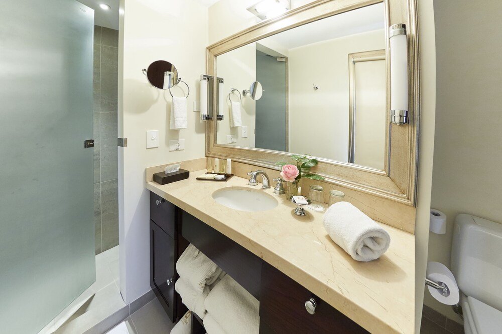 Baño moderno con espejo grande, dos lavabos y ducha