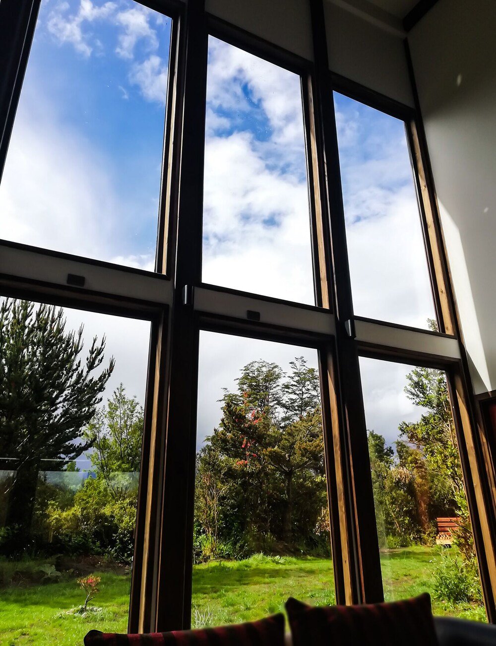 Room with large windows overlooking a garden and trees
