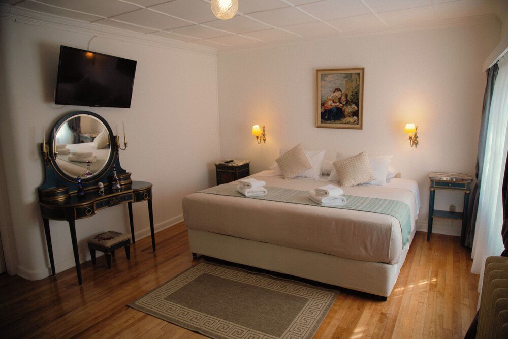 Dormitorio con una cama grande y una cómoda al lado