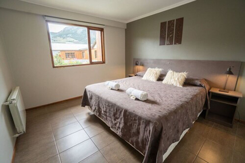 Dormitorio con cama grande y una ventana con vista