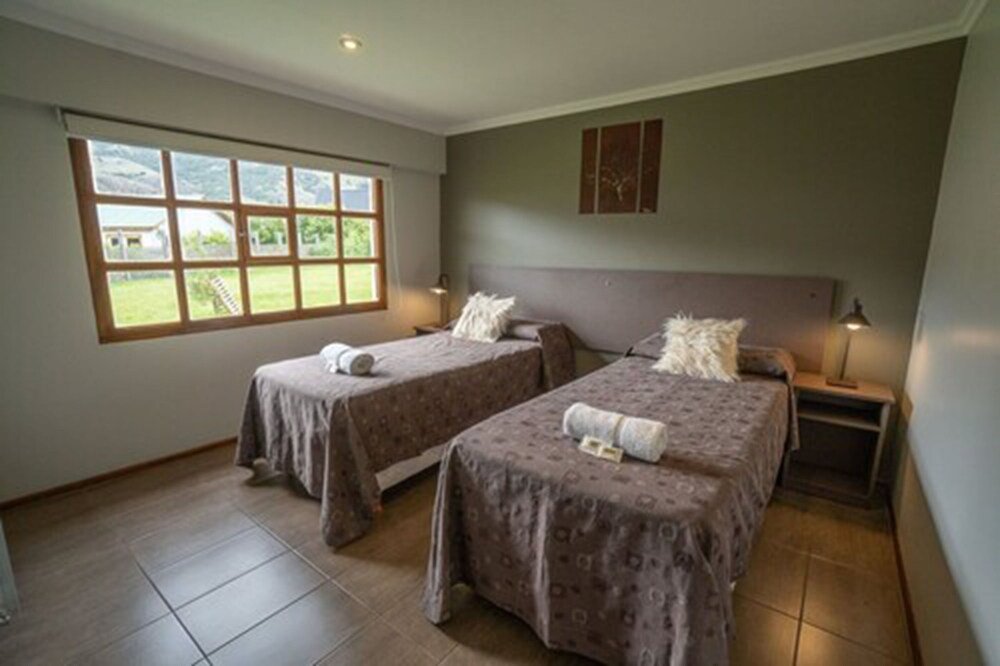 Habitación con dos camas y un gran ventanal