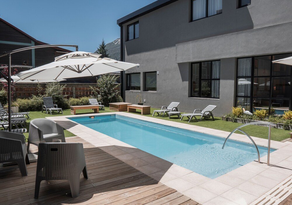Modern outdoor pool area with lounge chairs at Gluck Patagonia Aparts