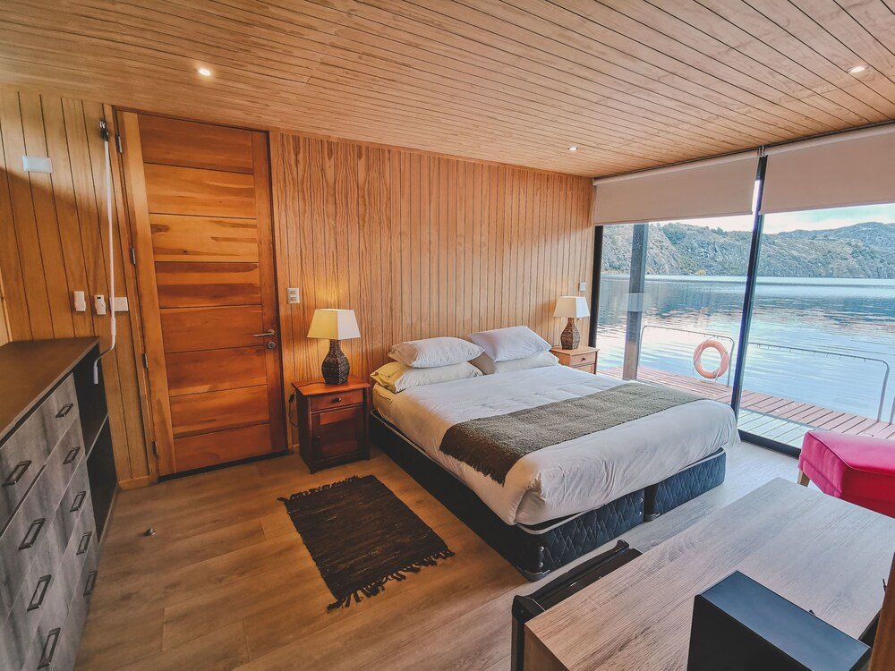 Dormitorio moderno con techo de madera y cama grande