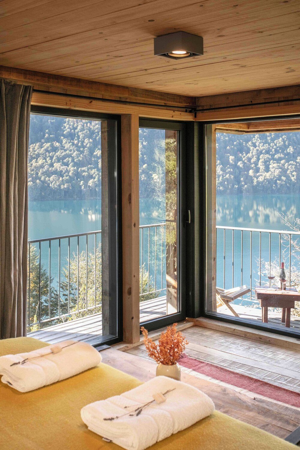 Bedroom with a wooden ceiling and large windows at the lodge