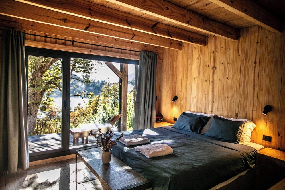 Wooden room with a bed and a small table at the lodge