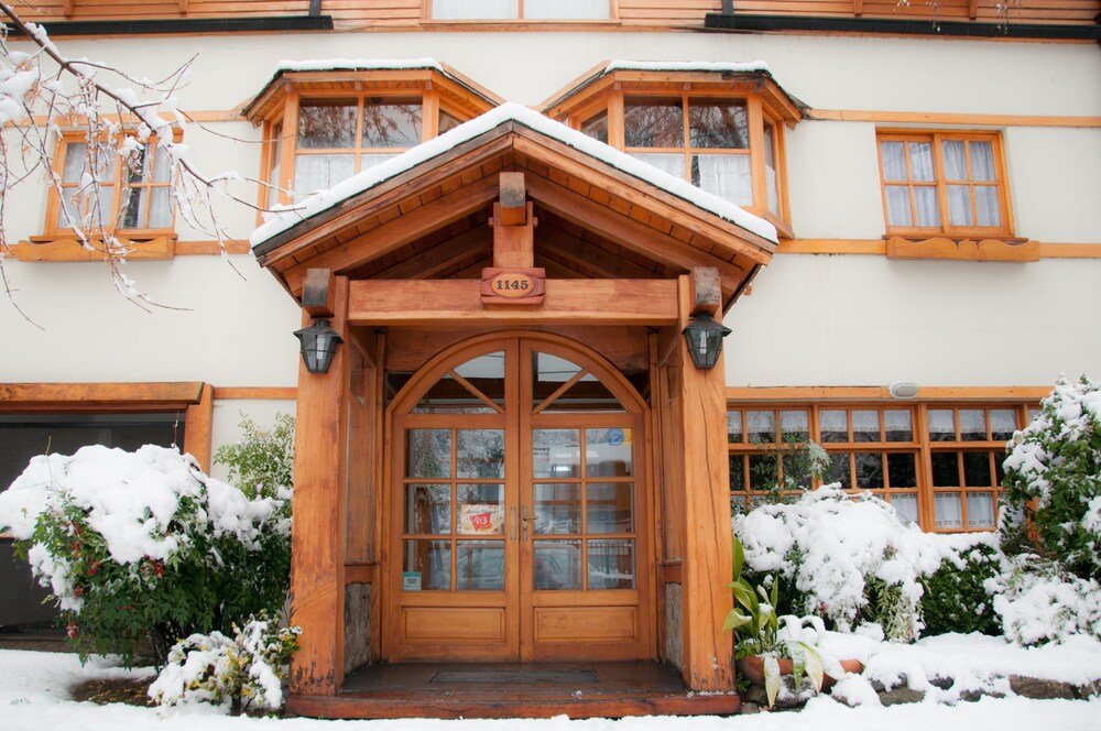 Wooden building with a snow-covered entrance and a sign