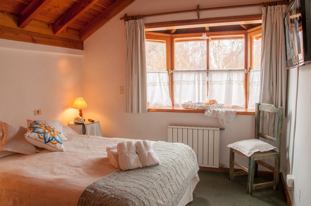 Cosy bedroom with a bed, a chair and a table with a lamp