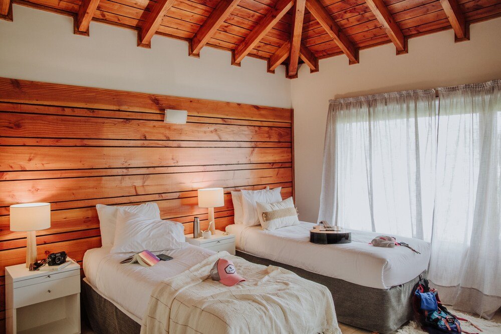 Habitación con dos camas y vigas de madera en el techo