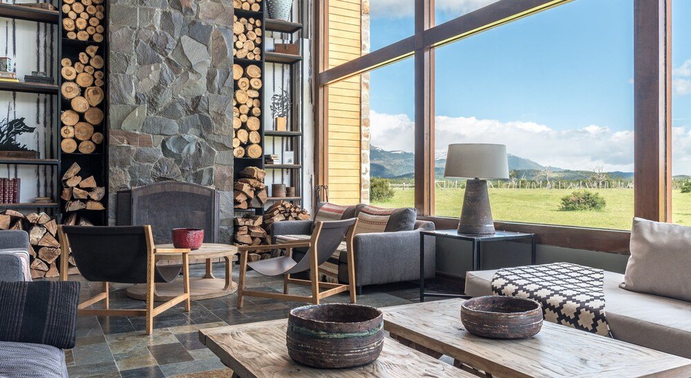 Living acogedor con chimenea de piedra y vista a la montaña