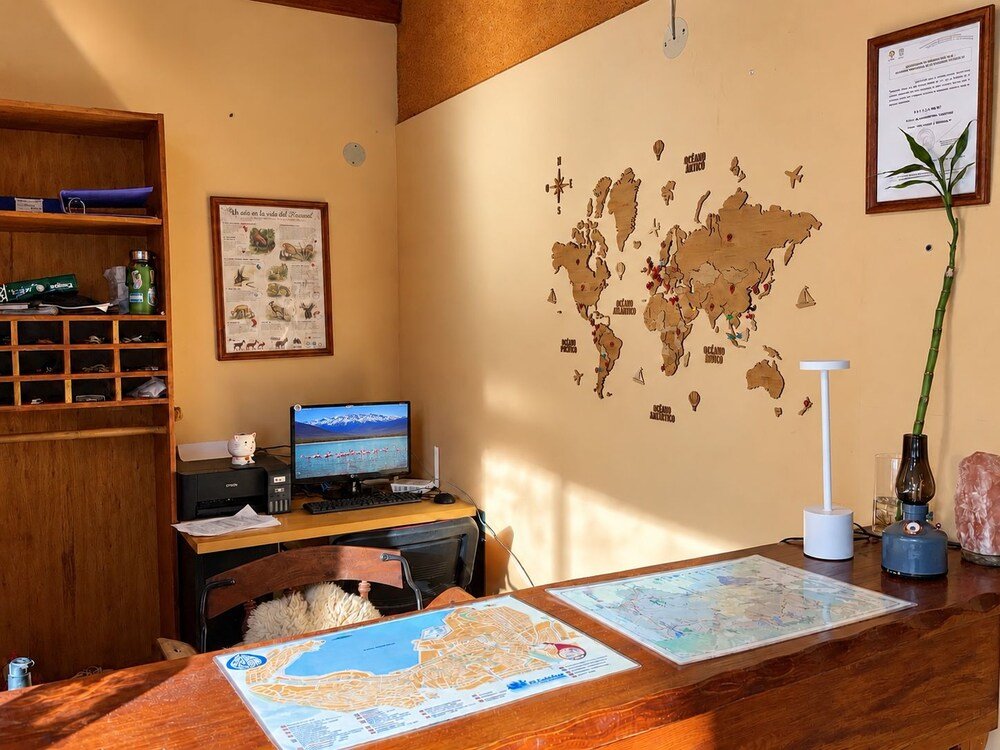 Room with a wooden desk, a computer and a wall map