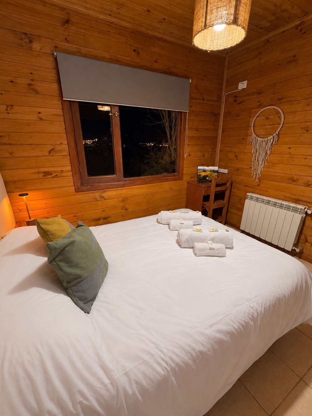 Wooden room with a bed and a wall-mounted dreamcatcher