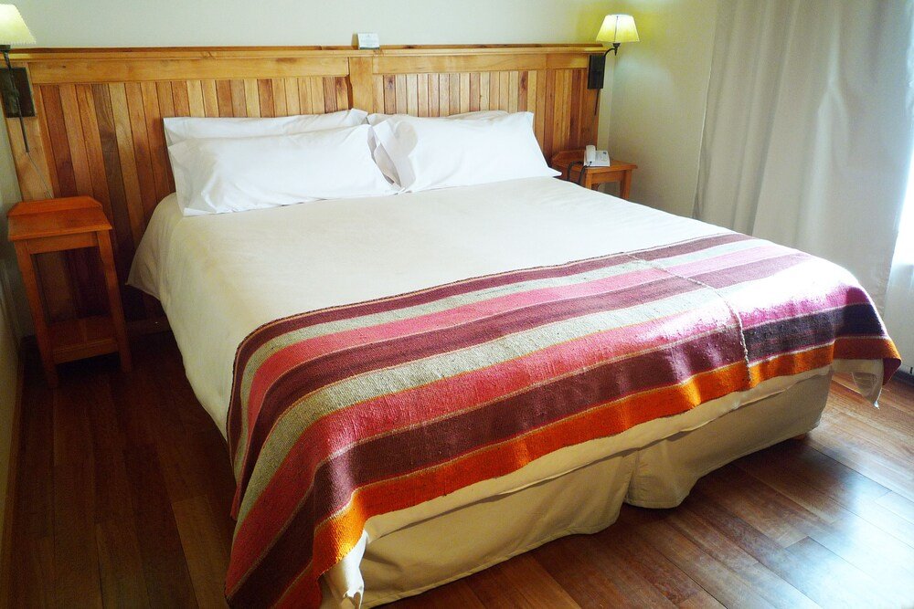 Bed with a wooden headboard and white pillows
