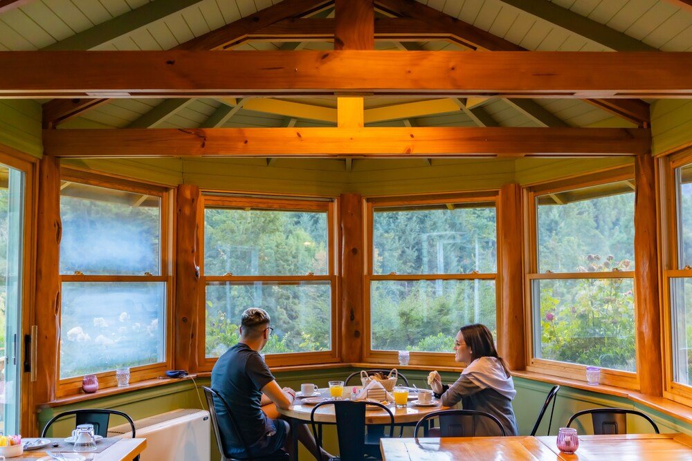 Wooden cabin-style building with large windows looking out to the forest
